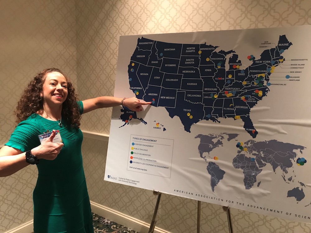 Dr. Mónica Ramírez-Andreotta at the 185th AAAS Annual Meeting. Dr. Mónica Ramírez-Andreotta pointing to Arizona on a map of the United States showing where different types of public engagement with science occur at the 185th AAAS Annual Meeting in Washington, D.C.